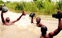 FLOOD PUTS S/SOUTH ASUNDER: Mortuary attendants stack corpses on roof tops