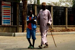 Photo of the day: Boy in uniform joins dad in street begging