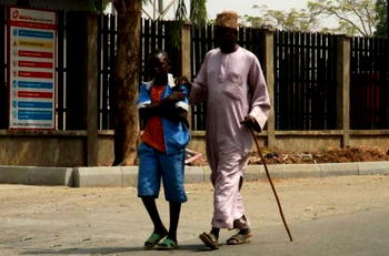 Photo of the day: Boy in uniform joins dad in street begging
