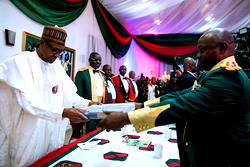 Photos: President Buhari receiving captured Boko Haram terrorist flag from Gen. Buratai