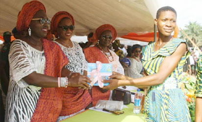 Wife of Ondo state Governor, Chief (Mrs) Betty Anyanwu - Akeredolu (left), presenting Certificate to one of the beneficiaries (right); Commissioner for Women Affairs and Social Development, Hon. Omowunmi Olatunji Edet (second left) at the Forum for Wives of Ondo State Officials, (FOWOSO) Empowerment Outreach Programme for Women, Youths and Special needs people in Akoko South West Local Government Area of Ondo State.