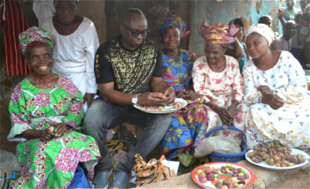 Photos: Fayose having fun with market women, buys kolanuts
