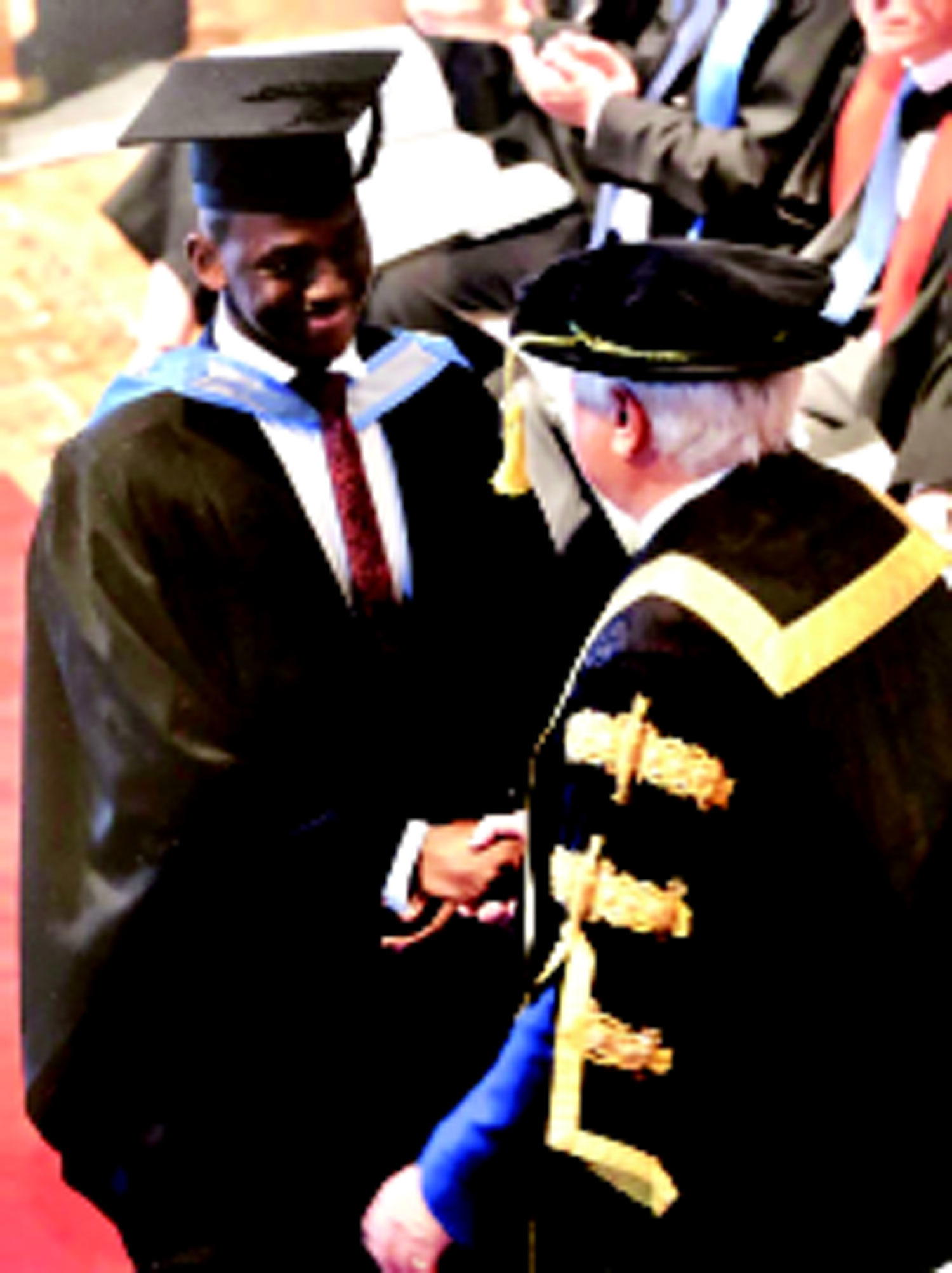 •Obi Akaeze(left)being congratulated by a don amidst other graduands during his graduation in Uk.
