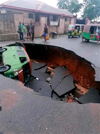 PHOTOS: Heavy gridlock as bus falls into huge sinkhole after downpour in Aba