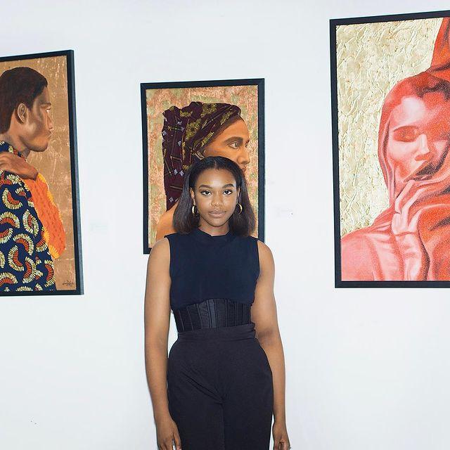 Donna Duke standing in front of her art works