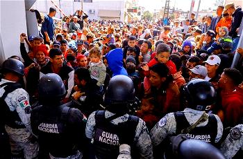 Migrants storm Mexico border to enter US