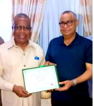 Emil Inyang presents his certificate of return to the deputy gov of Cross Rivers