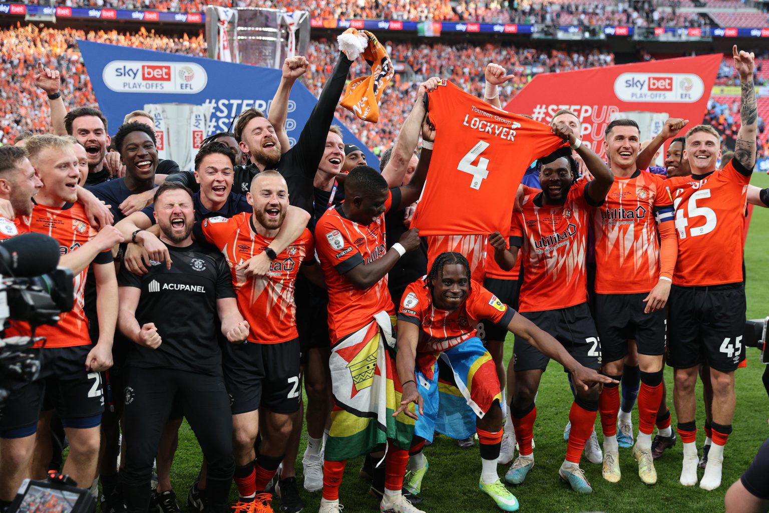  Luton Town players celebrating their victory in the 2022 EFL League Two play-off final at Wembley Stadium after beating Grimsby Town 2-0.