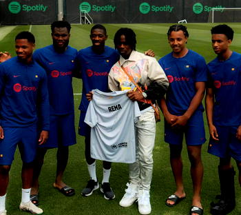 Rema visits Barca players during training, gets customised jersey