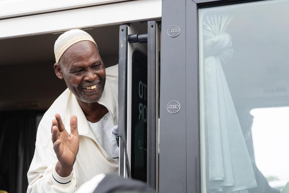 A migrant waves goodbye before leaving Sudan with the support of IOM. Photo credit: IOM