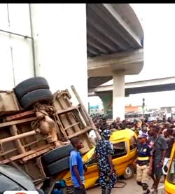 Truck plunges from Pen Cinema Bridge, crushes two buses in Lagos